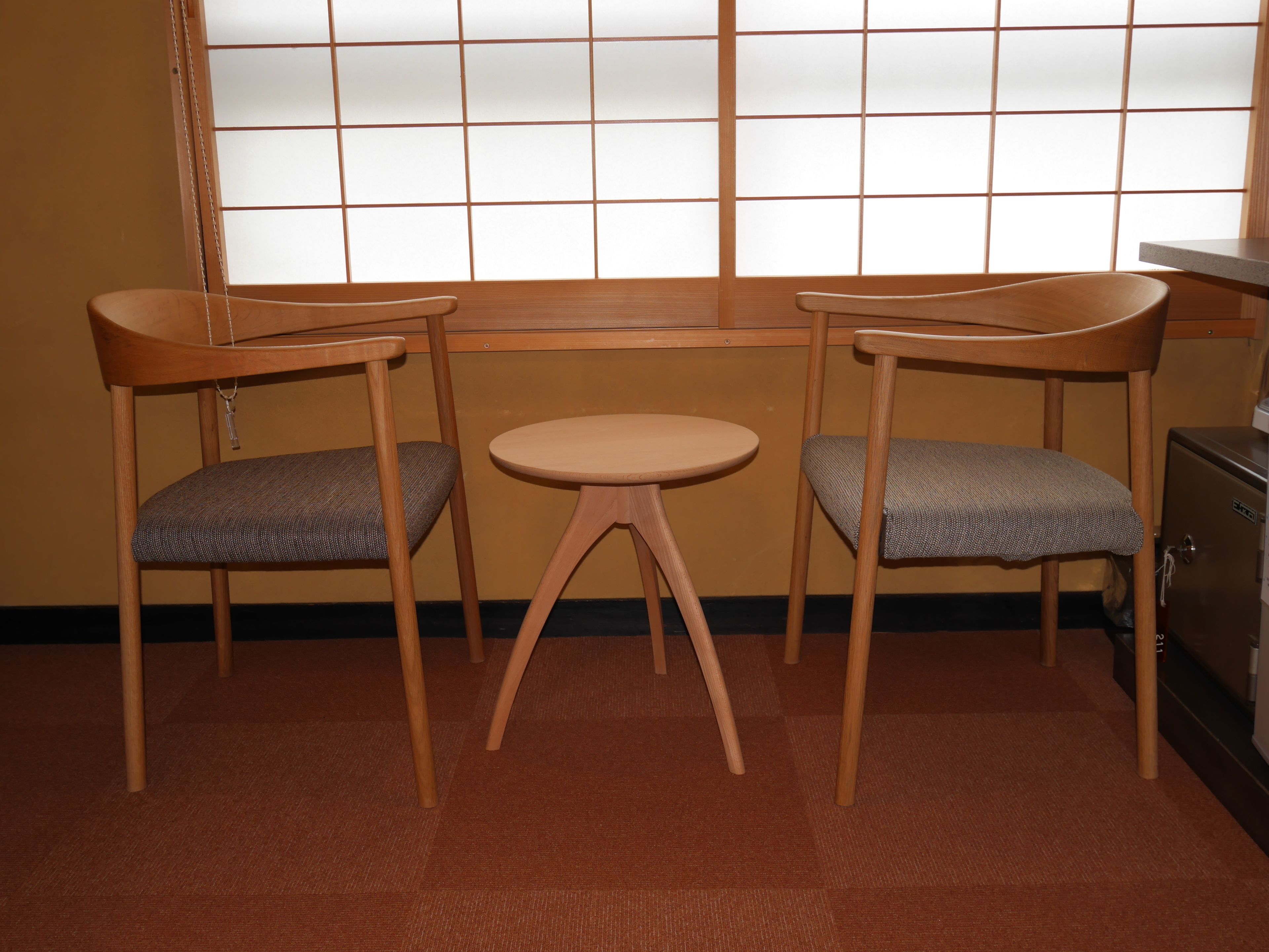 A room with two wooden chairs and a small round table.