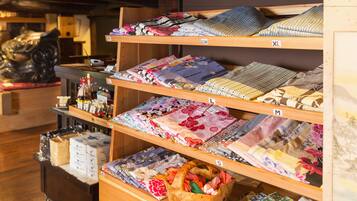 A store with shelves of folded fabrics and a wooden display case with boxes.
