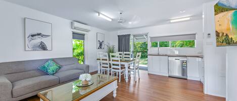 A modern living area with a sofa, dining table, and kitchen.
