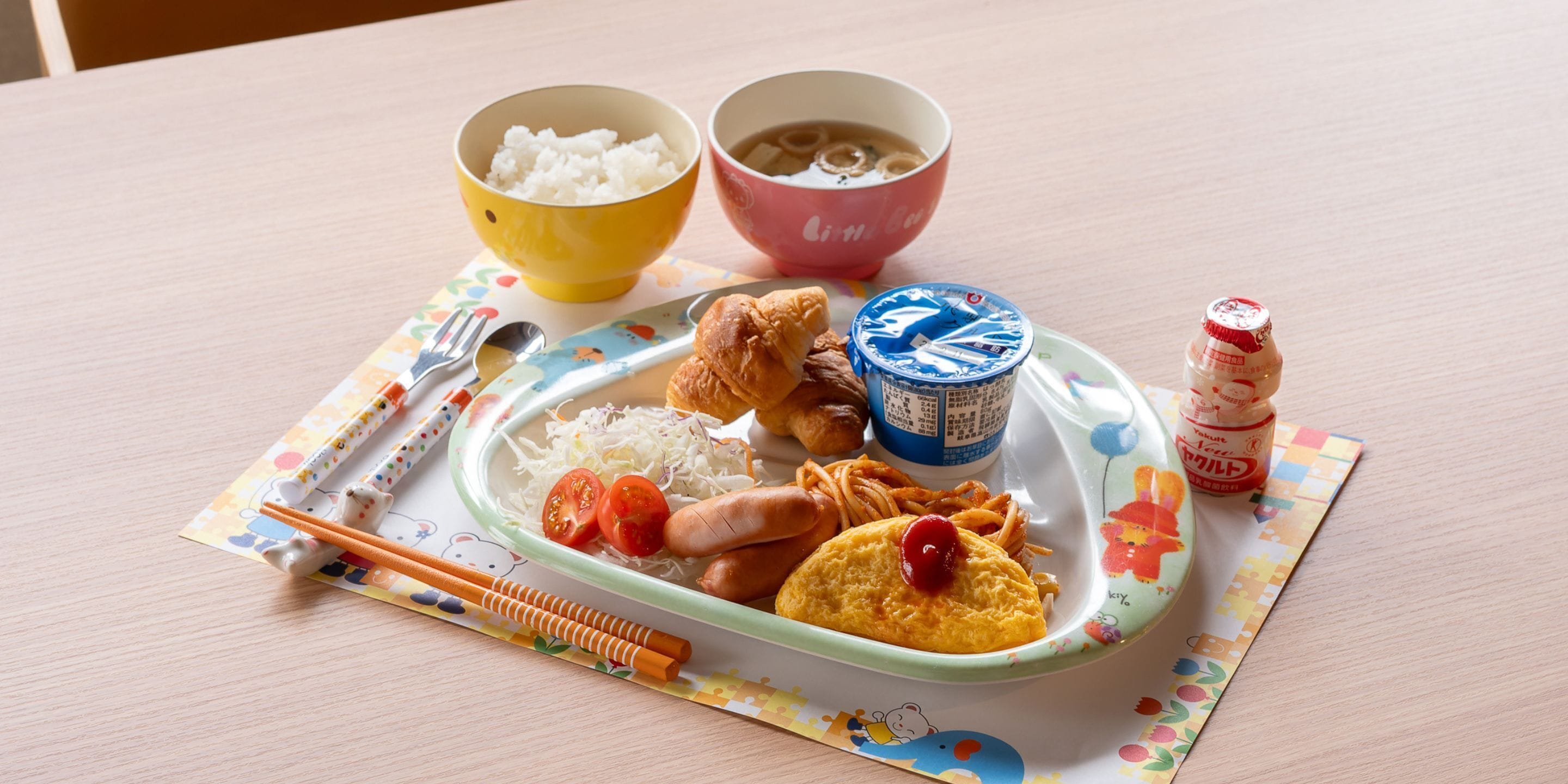 Un plateau repas contenant du riz, de la soupe et un petit récipient de sauce soja.