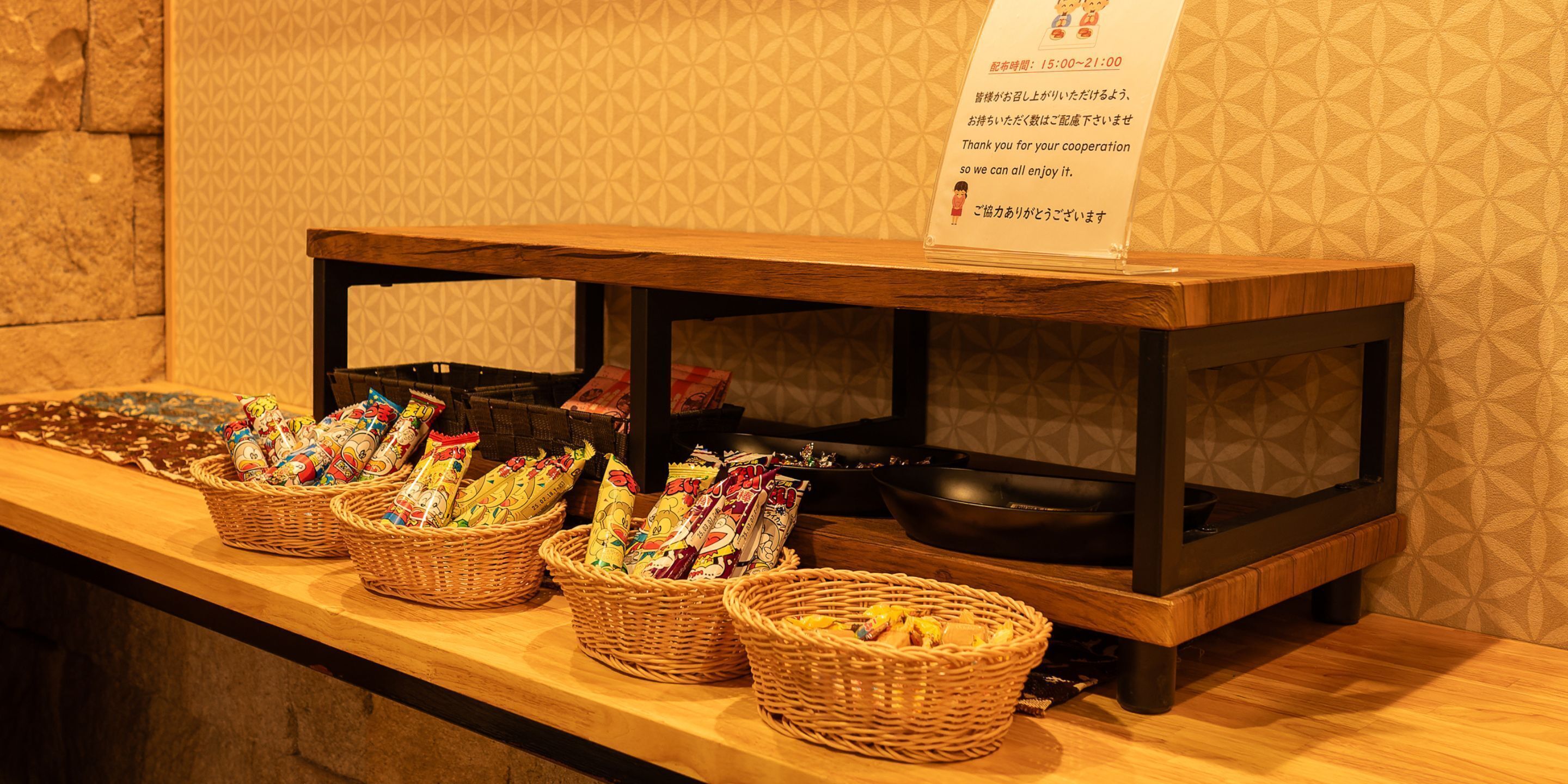 A buffet setup with baskets of snacks and a sign with operating hours.