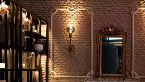 A cozy room with a brick wall, a fireplace, a sofa, and a bookshelf. - Xenon Inn (Nafplio)