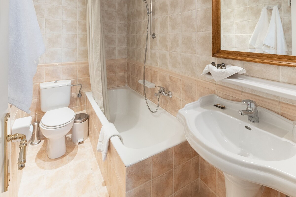 Un baño con inodoro, bidé, ducha, bañera y lavamanos.