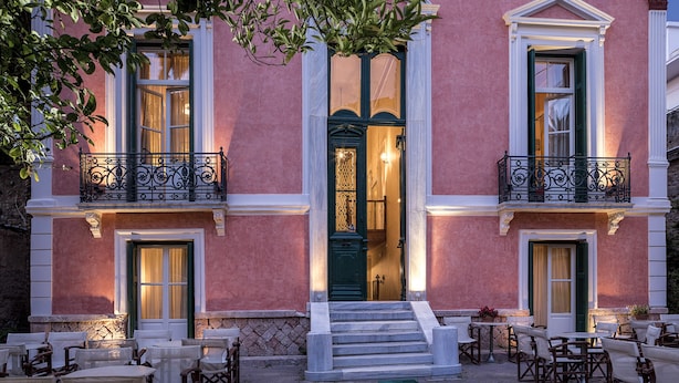 A pink building with a green door, white trim, and a balcony with black iron railings. - Nafsimedon Hotel (Nafplio)