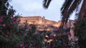 A historic fort with a prominent tower, surrounded by desert vegetation. - Nafsimedon Hotel (Nafplio)