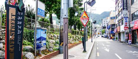 Une rue où l’on trouve des panneaux indiquant l’église catholique de Jeonpo et la zone de sécurité de Jeongpo.