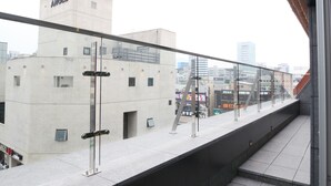 Een terras op het dak met uitzicht op een gebouw met de tekst 'ANGEL' en een stadslandschap op de achtergrond.