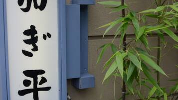 A sign with Japanese characters and the name "KAGIHEI" on a building.