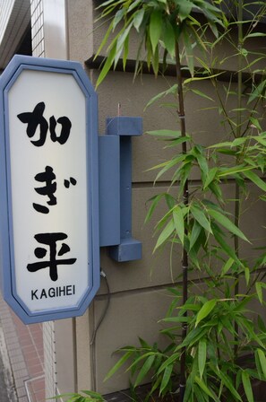 A sign with Japanese characters and the name "KAGIHEI" on a building. - Ryokan Kyo-no-yado Kagihei (Kyoto)