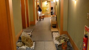 A hotel hallway with a stone pathway, wooden benches, and a fire extinguisher on the wall. - Ryokan Kyo-no-yado Kagihei (Kyoto)