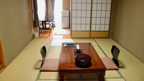 A traditional Japanese room with tatami flooring, a low wooden table with a bowl, chopsticks, and a remote control. - Ryokan Kyo-no-yado Kagihei (Kyoto)