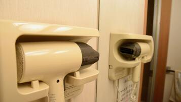 A hairdryer and a plug in a bathroom.