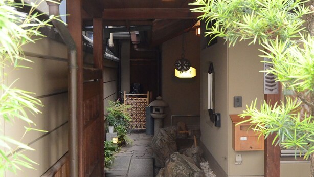 A traditional Japanese-style entrance with a tiled roof, stone pathway, and wooden structures. - Ryokan Kyo-no-yado Kagihei (Kyoto)