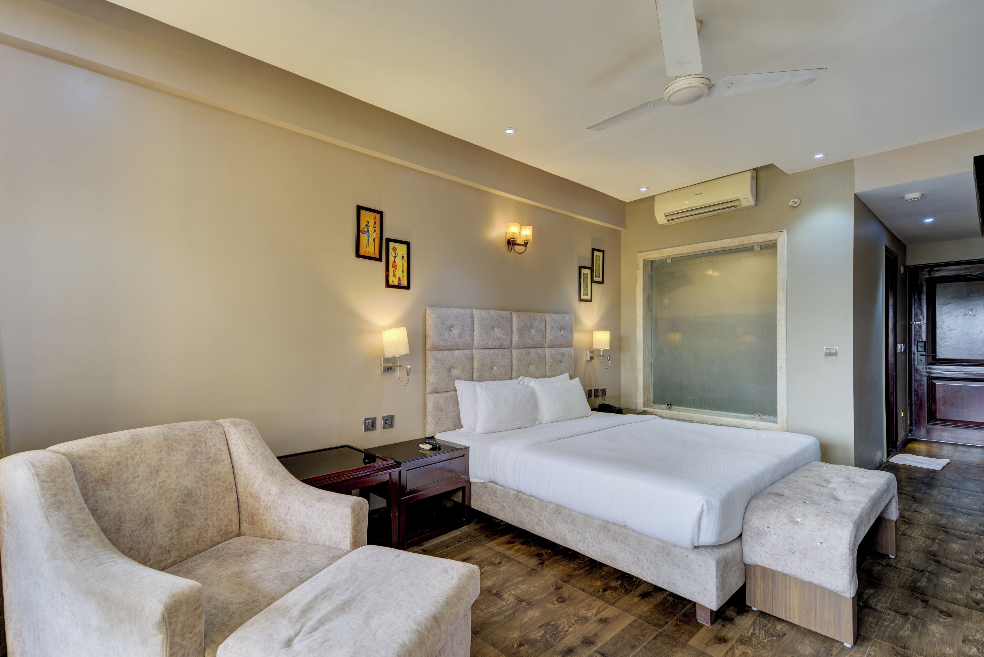 Una camera d'albergo con un letto grande, una sedia, una scrivania e uno specchio.