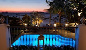 A swimming pool with a view of the sea at dusk. - Pousada Casa Nova Buzios (Buzios)