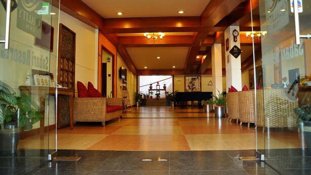 Eine geräumige Lobby mit hoher Decke, Holzbalken und einem Klavier in der Mitte.