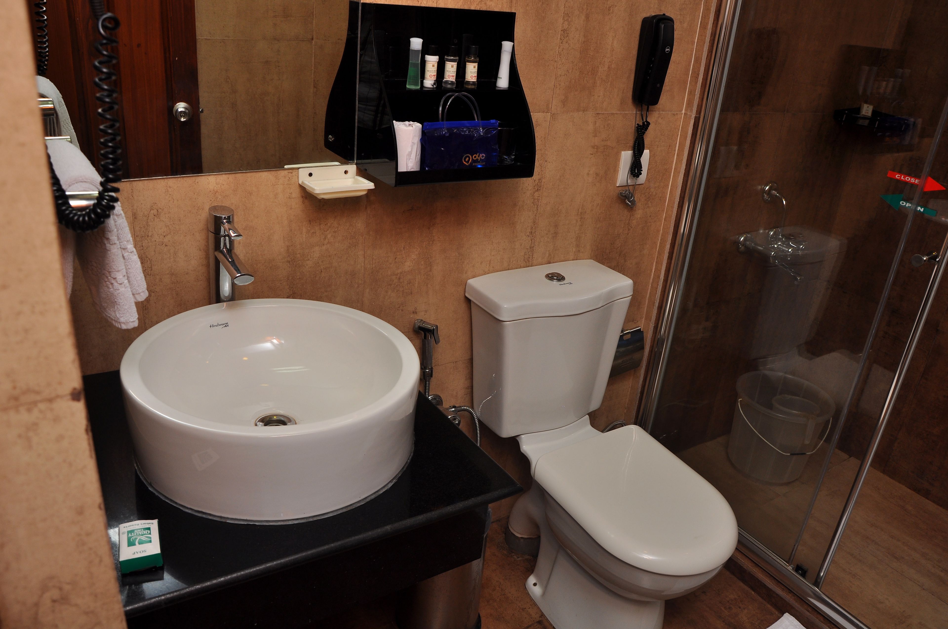 A bathroom with a large sink, toilet, and a glass shower enclosure.