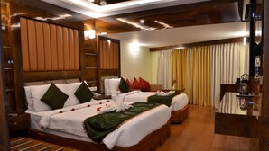 Ein Hotelzimmer mit zwei Betten, Holz Kopfteilen, einem kleinen Tisch und einem Spiegel.