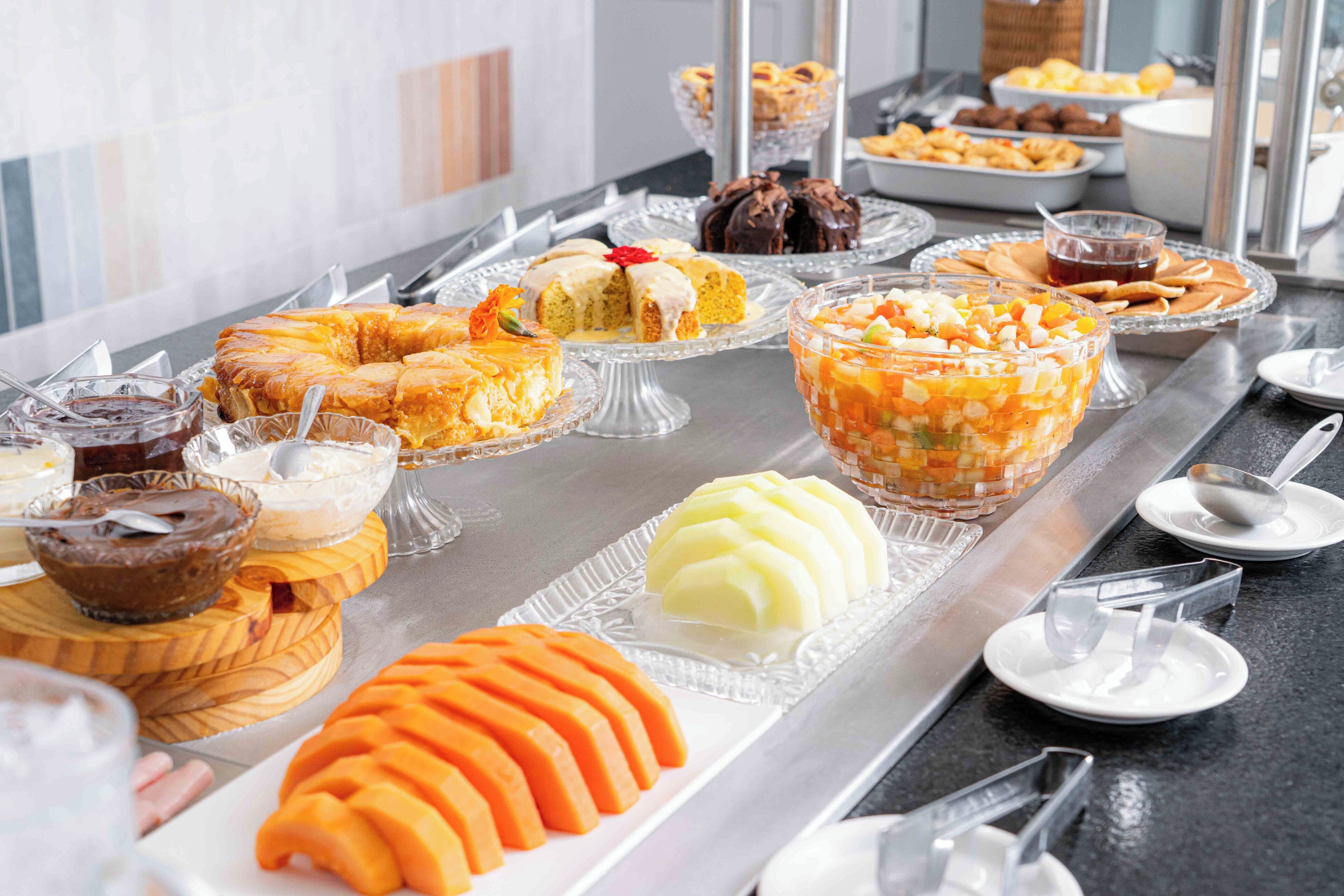 A buffet with various desserts and fruits.