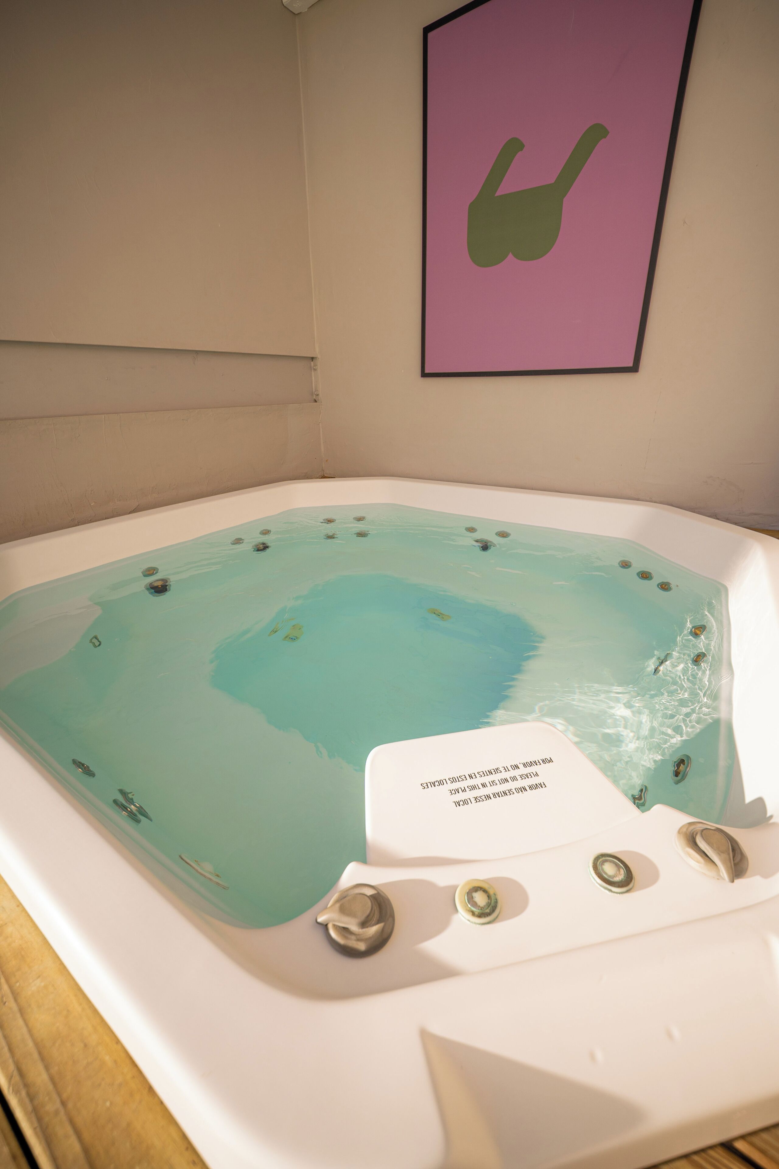 Un jacuzzi con un panel de control y un letrero adherido a la pared.