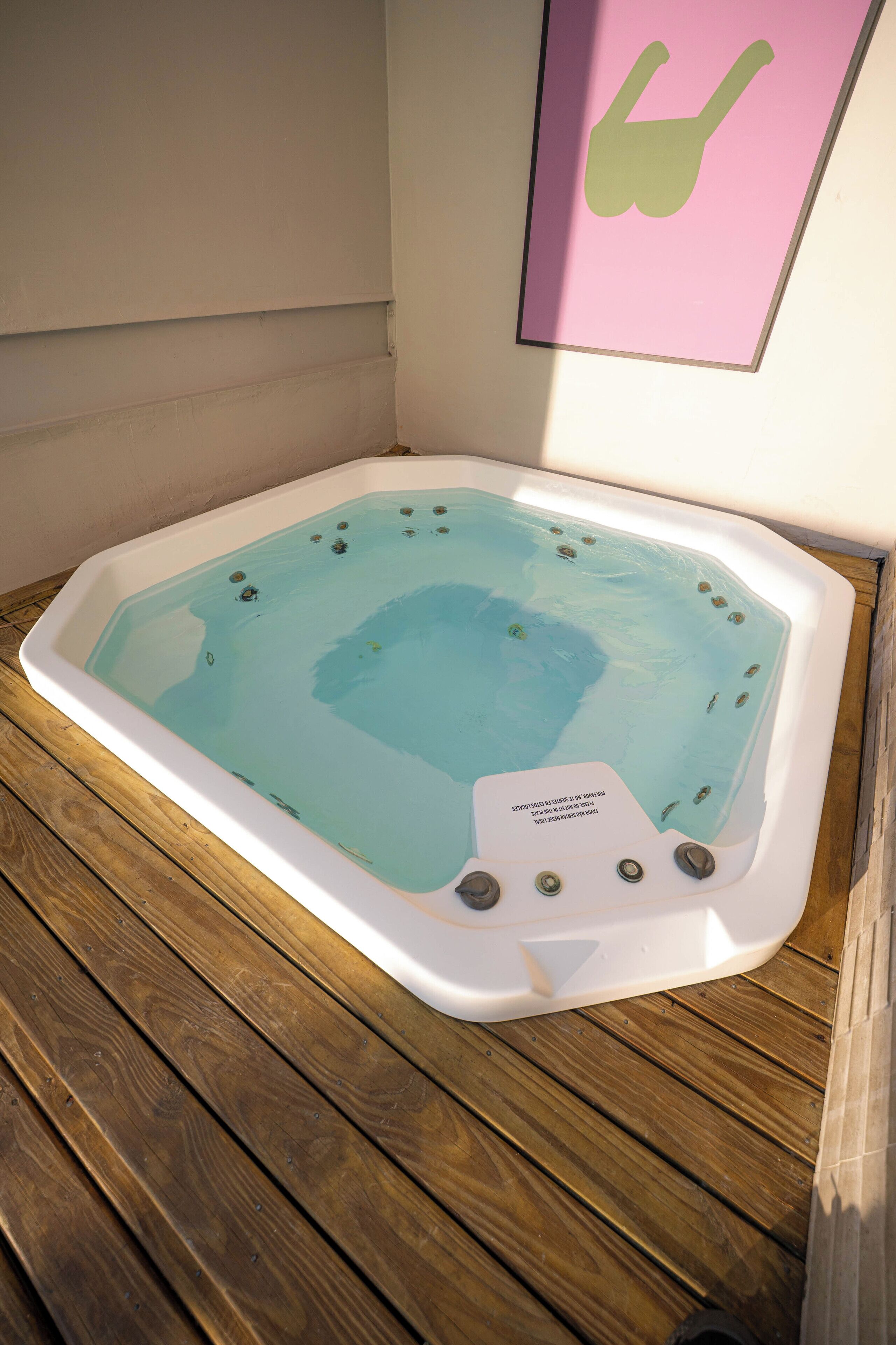 A hot tub with a wooden deck surrounding it.