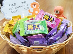 Un panier rempli de sachets colorés de produits à ajouter à l’eau du bain.