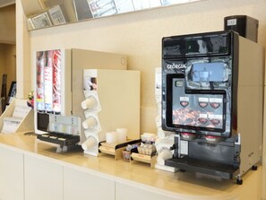 Una máquina de café y un dispensador de Coca-Cola en una barra.