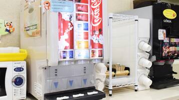 A vending machine area with a Coca-Cola machine, a water dispenser, and a coffee machine.