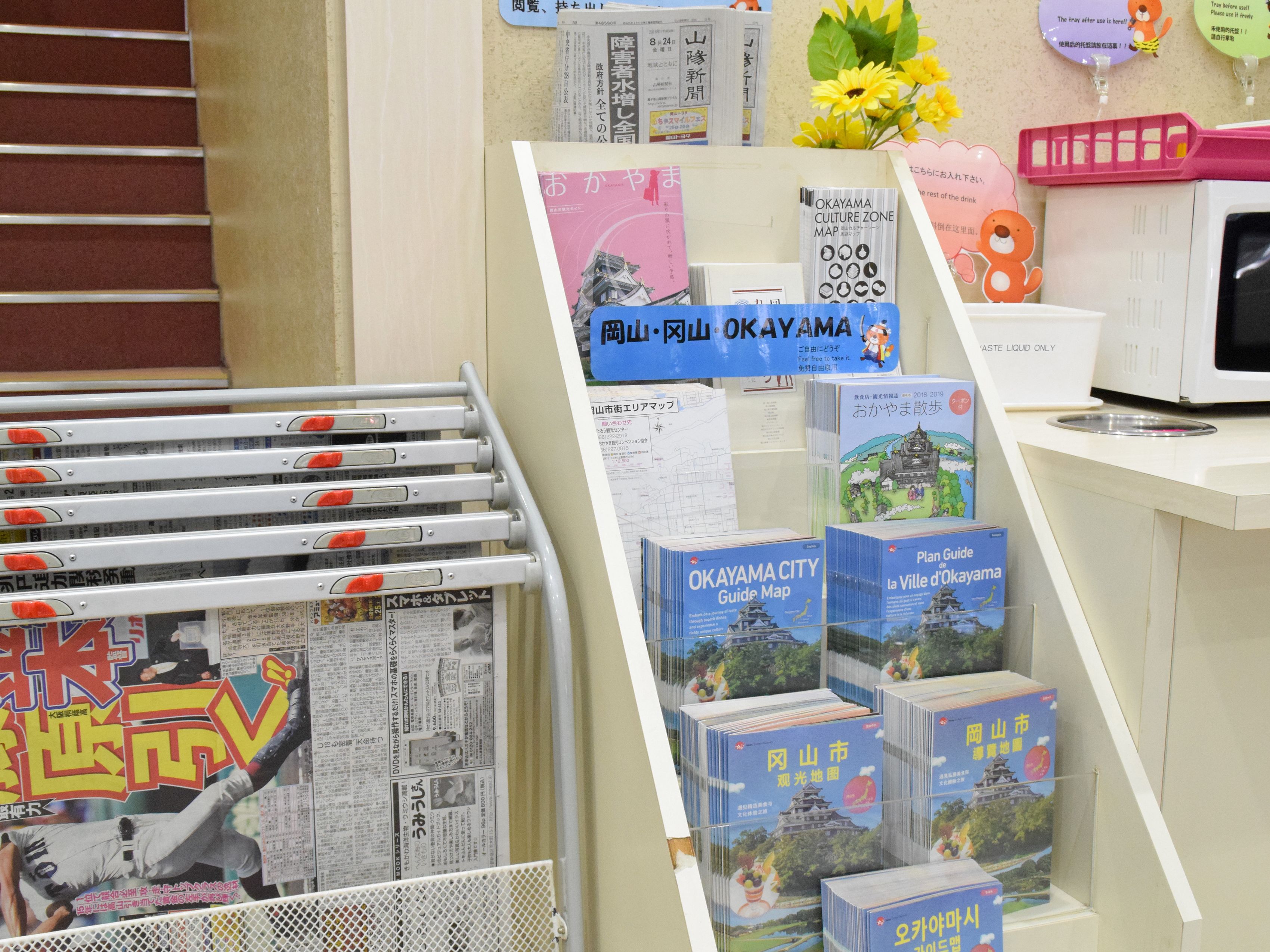 Une exposition de guides de voyage et de cartes de la ville d’Okayama, comprenant un plan touristique et un plan de la ville.