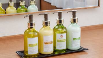 A tray with four bottles of skincare products on a wooden surface.