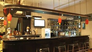 Eine Bar mit Guinness-Branding, einem Fernseher und einer Theke voller verschiedener Flaschen.