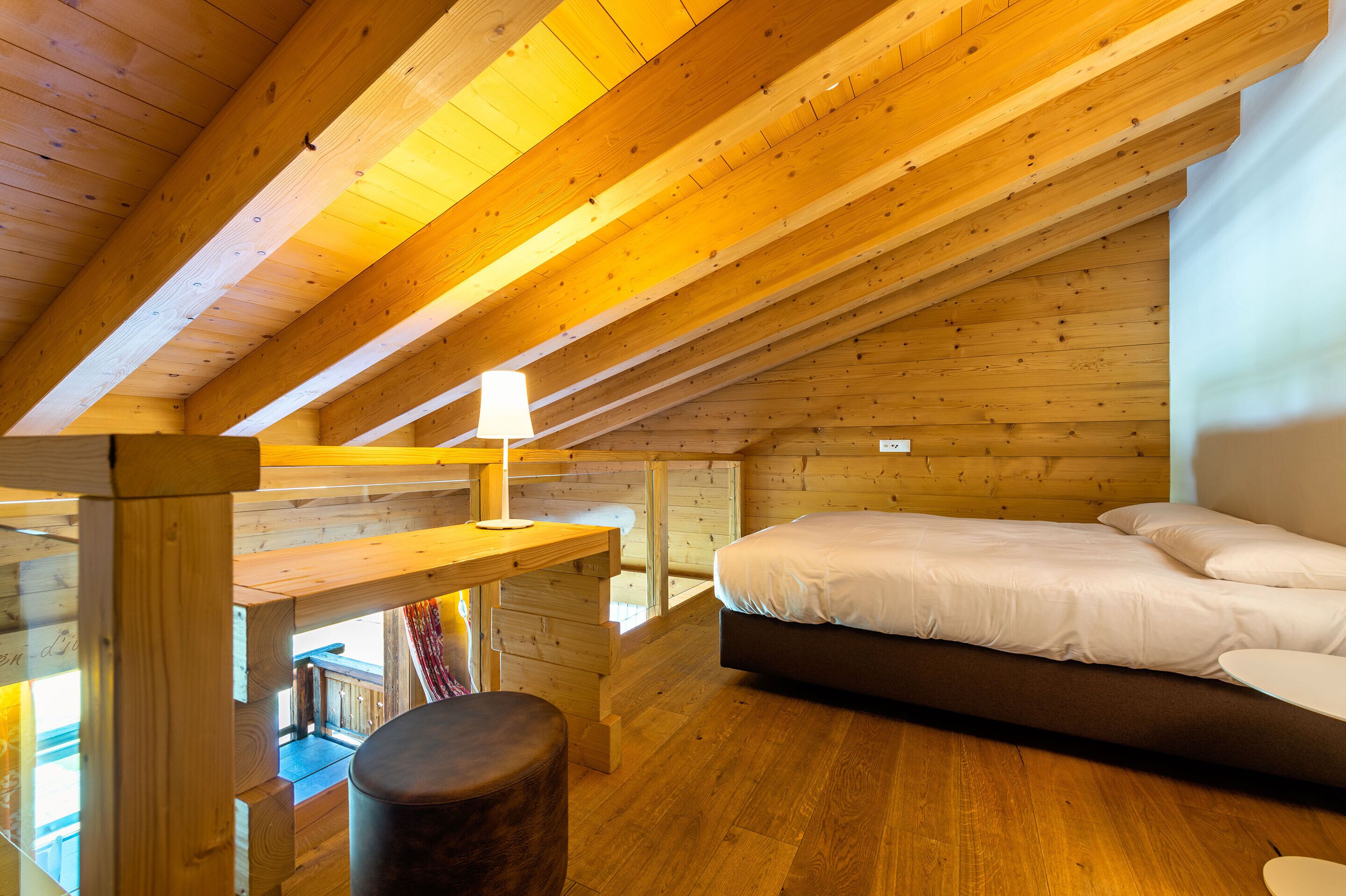 Un interno in legno con un letto, un tavolo e una panca.