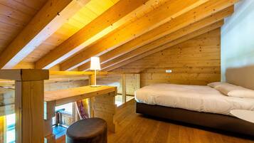 Un interno in legno con un letto, un tavolo e una panca.