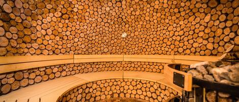 A sauna with a wooden log wall and benches.