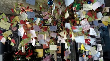 A wall decorated with numerous handwritten notes and colorful paper decorations, including a small Christmas tree.