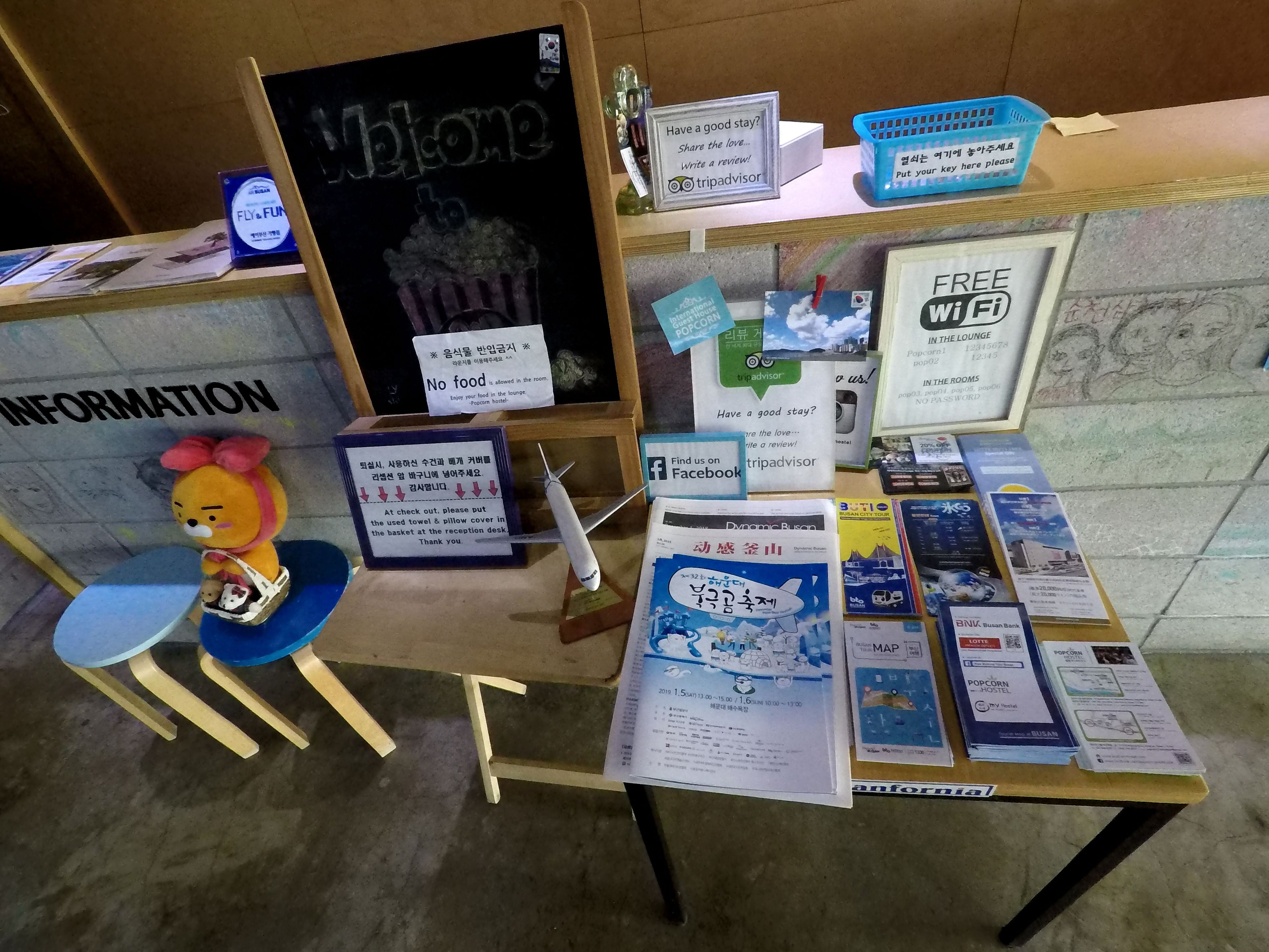 Een receptiebalie met informatieborden, een pluche speelgoed en diverse brochures.
