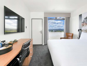 A hotel room with a bed, a desk, a chair, a TV, a door, and a window with a view. - Mercure Launceston (Launceston)