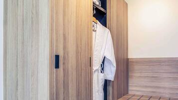 A wooden wardrobe with a hanging rack, a bench, and a small shelf.