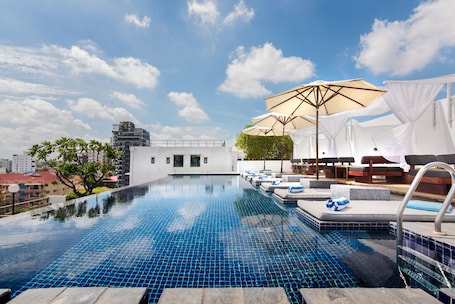 Una piscina al aire libre, sillones reclinables de piscina