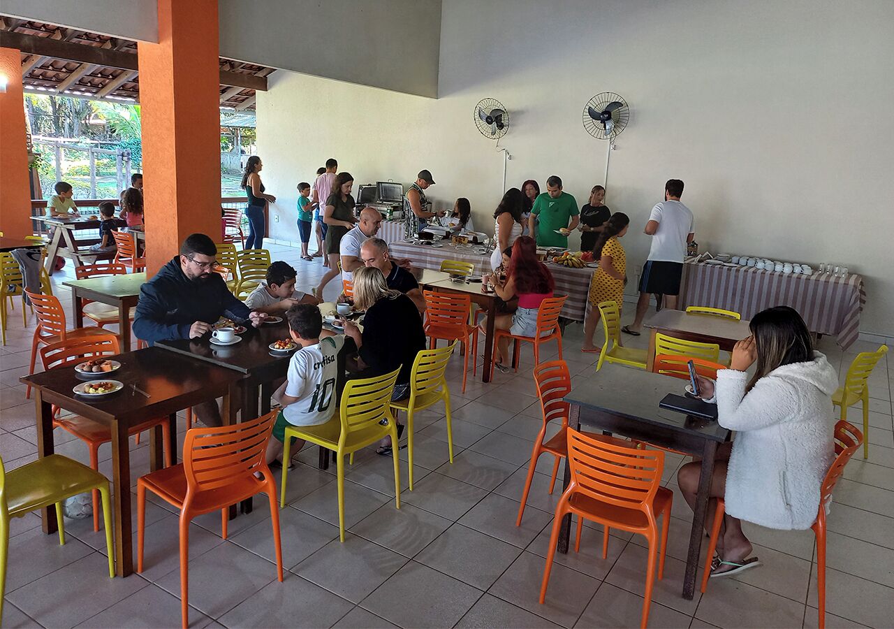 A dining area with tables and chairs, a buffet setup, and fans on the walls.