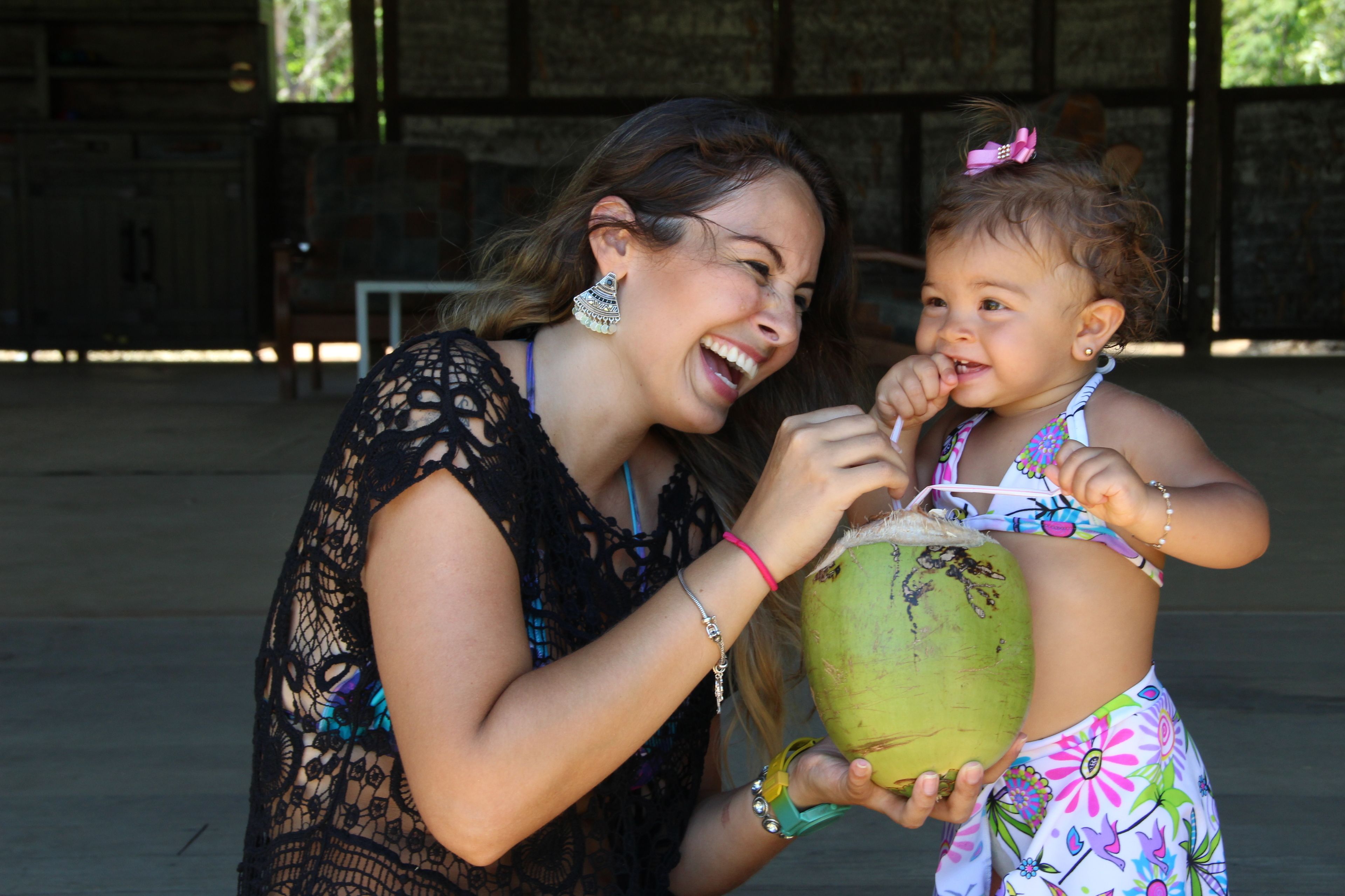 A woman and a child holding a coconut.