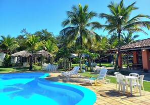 Una piscina con tumbonas y palmeras.