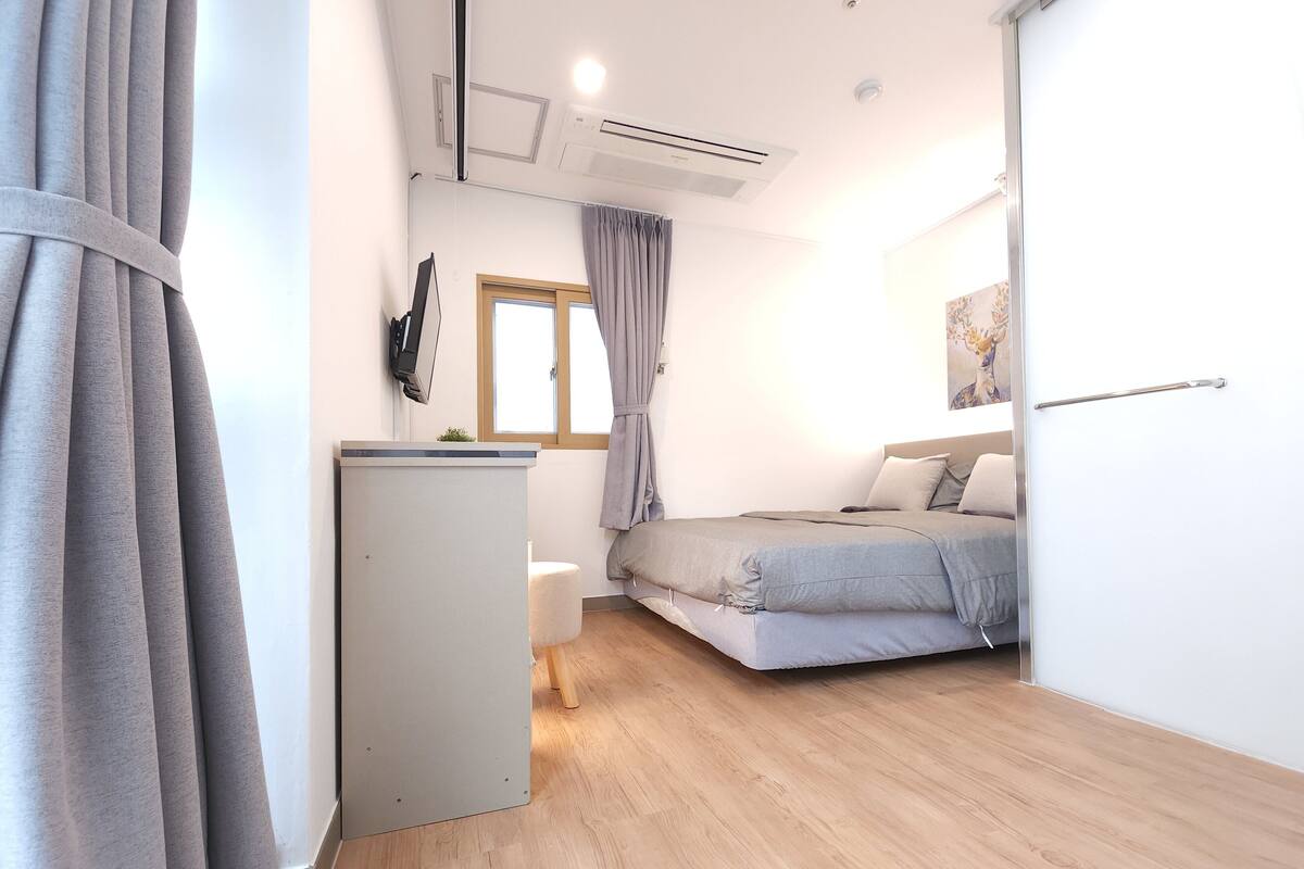 Een moderne slaapkamer met een bed, een bureau en een raam.