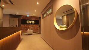 A reception area with a 'OYO' sign, a reception desk, a mirror, and a small plant. - OYO Hostel Myeongdong 2 (Seoul)