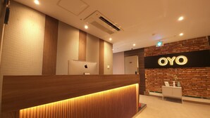 A reception desk with a wooden finish and a lit-up sign that reads "OYO". - OYO Hostel Myeongdong 2 (Seoul)