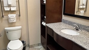 Un baño con inodoro, lavabo, espejo y perchero para toallas.