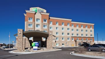 A Holiday Inn Express building with a brick facade, multiple windows, and a covered entrance.