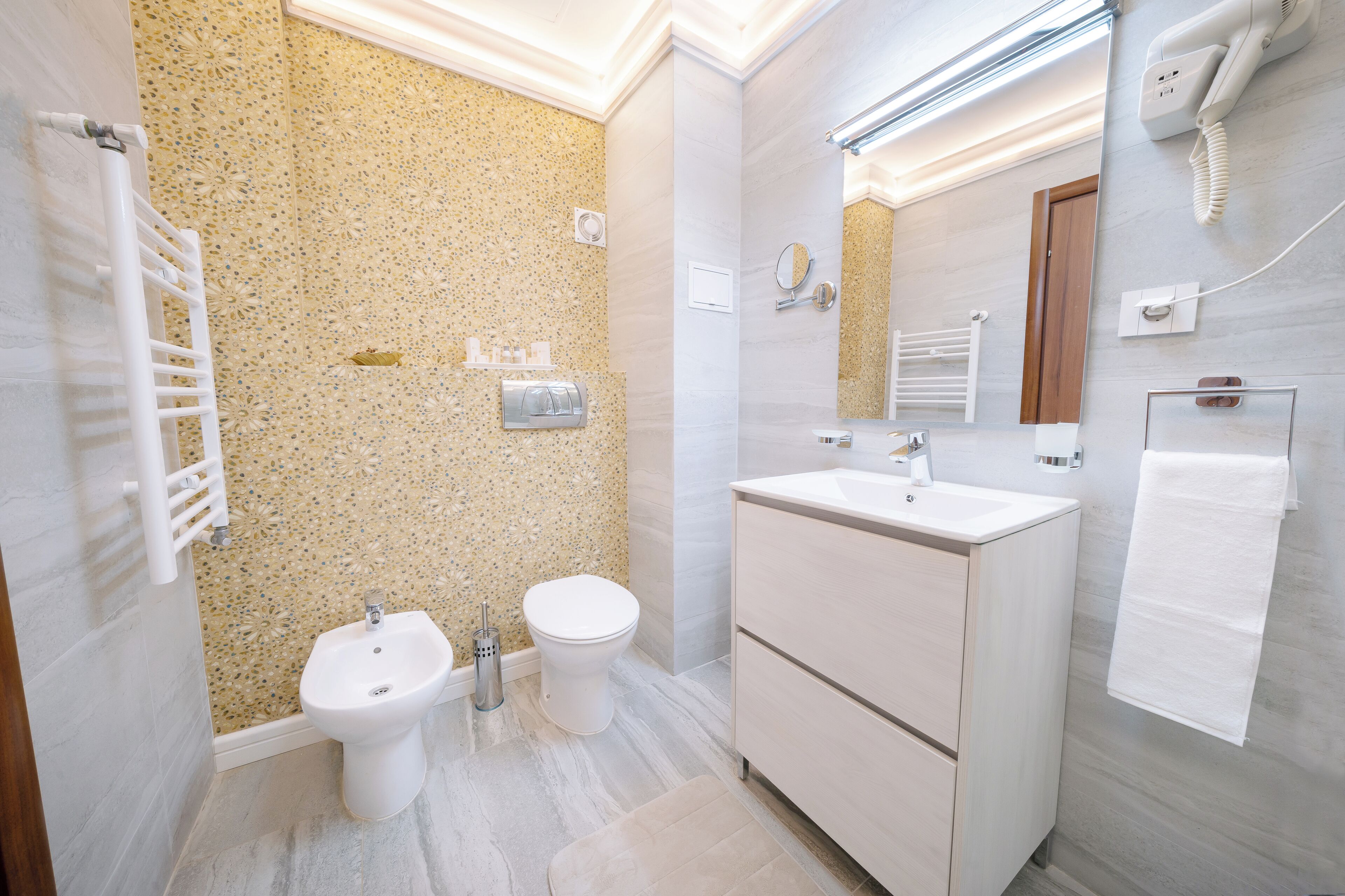 Une salle de bain moderne équipée d’un bidet, de toilettes et d’un meuble-lavabo.