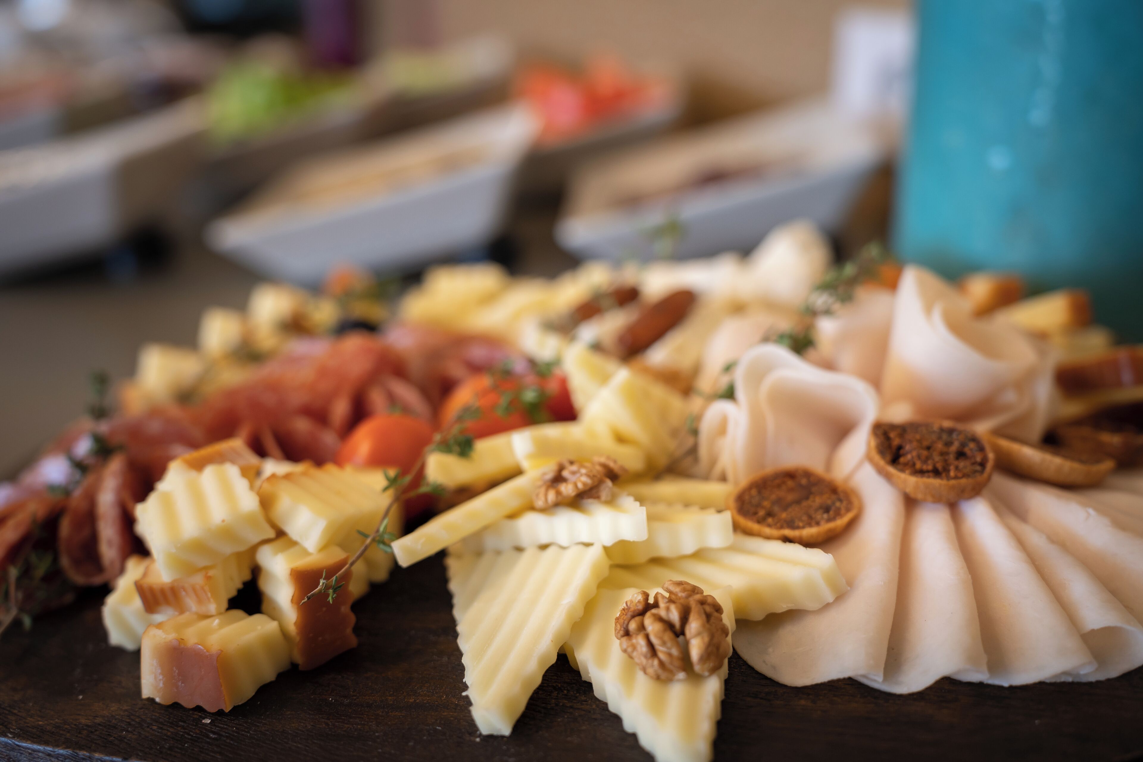 A charcuterie board with various cheeses, nuts, and fruits.