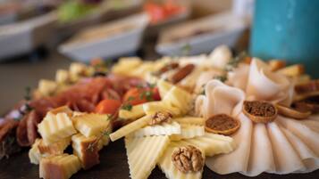 A charcuterie board with various cheeses, nuts, and fruits.